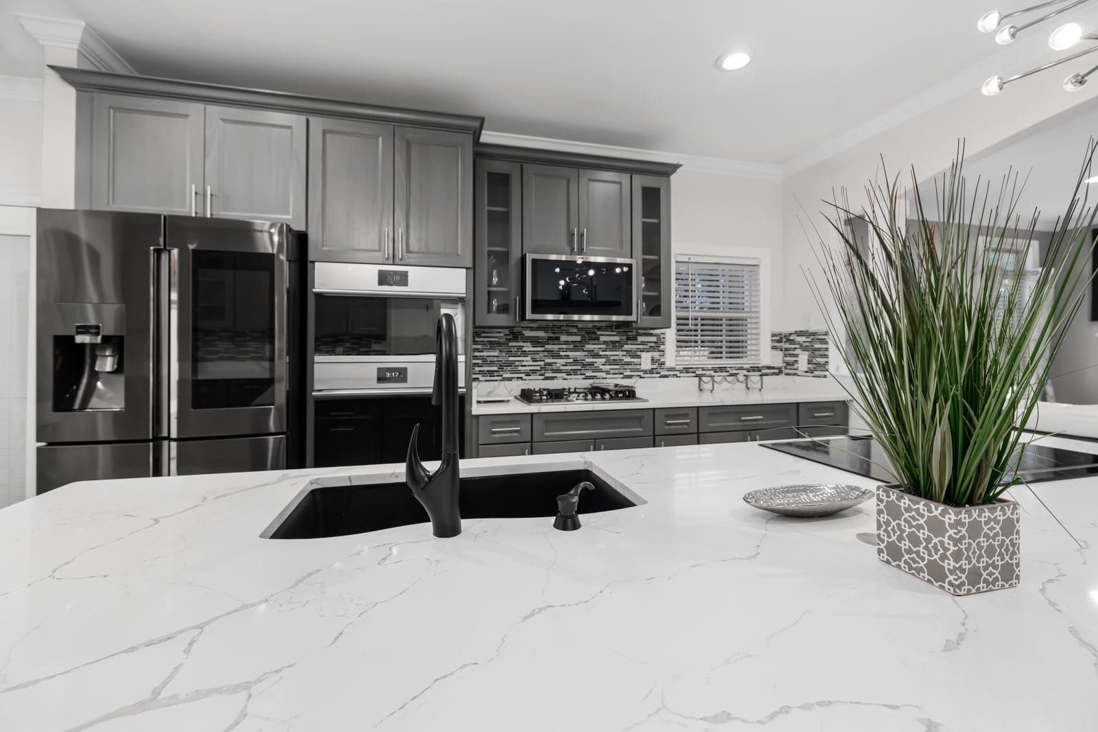 White quartz kitchen island with soft grey veining and an undermount sink